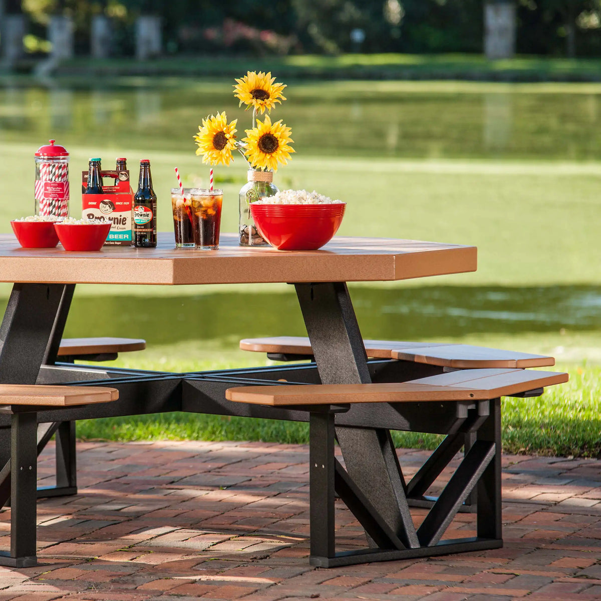 LuxCraft POPT, supplier side patio view showing the octagonal tabletop, attached benches and support frame in a two-tone finish. Manufacturer finish/configuration example; select the desired options separately. Tableware, blankets and decorative accessories are not included.