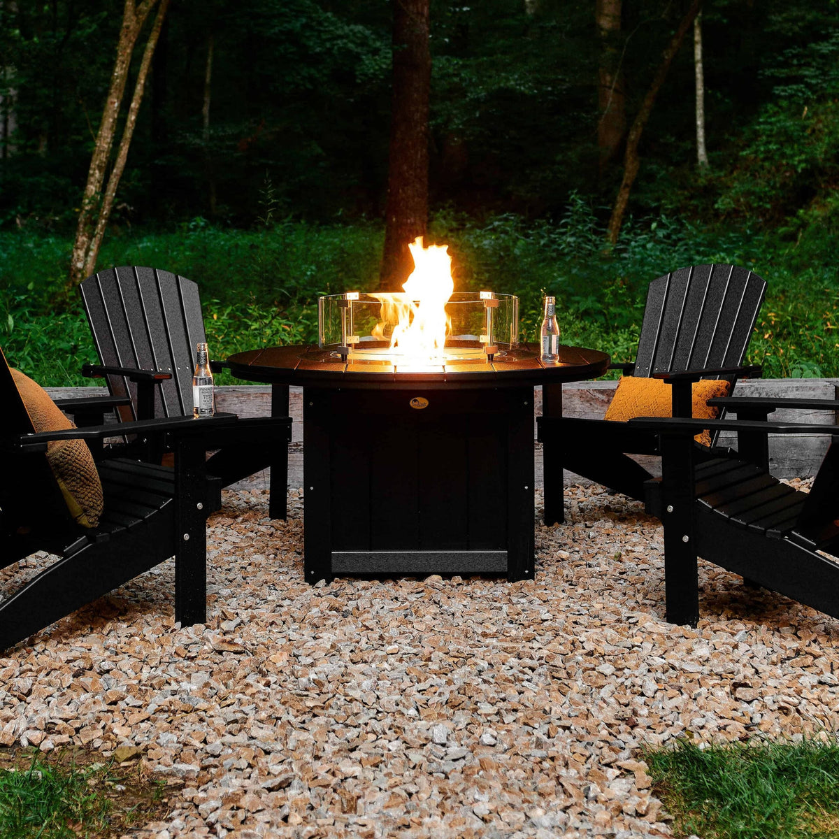 LuxCraft Lumin LFP46R 46-inch round fire pit in a manufacturer outdoor setting, showing the flame and circular glass wind guard; dark-finish example, chairs and accessories not included
